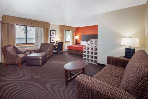 a hotel room with a bedroom and a bed at AmericInn by Wyndham Ashland in Ashland