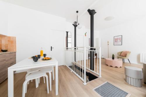 une salle à manger blanche avec une table et des chaises blanches dans l'établissement Appartement luxueux avec salle de bains de reve 6P - FLAT-GUEST, à Paris