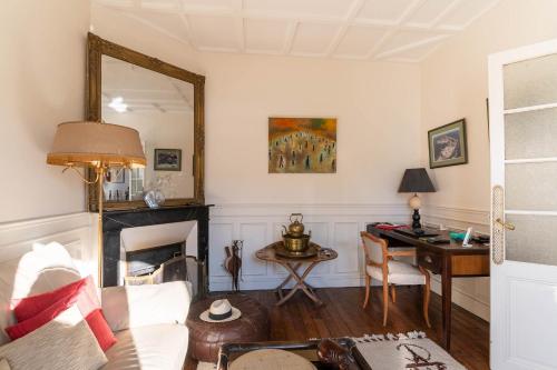 - un salon avec un canapé, un bureau et un miroir dans l'établissement Le Refuge de Charentonneau - A 30 min de Paris, à Maisons-Alfort