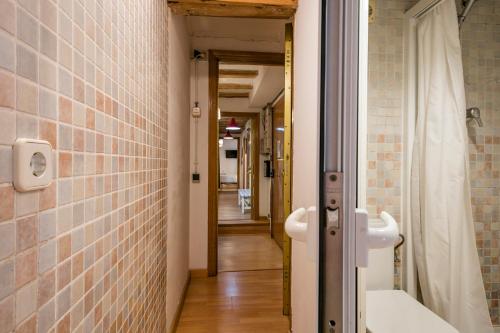 a bathroom with a tub and a toilet and a hallway at Encanto en Las Ramblas: Espacio perfecto para 9 in Barcelona