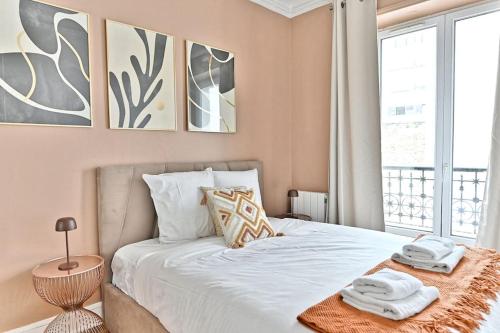 une chambre avec un lit avec deux serviettes dessus dans l'établissement Appartement coloré Paris Rue Niépce, à Paris