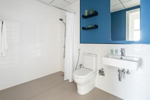 a white bathroom with a toilet and a sink at Frank Porter - The Nook 2 in Dubai