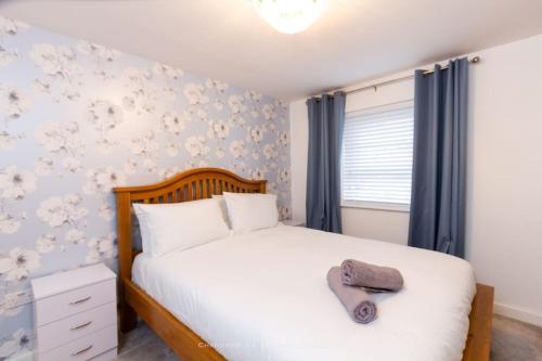 a bedroom with a white bed with a towel on it at Cosy Home in Picturesque Village Cottingham in Cottingham