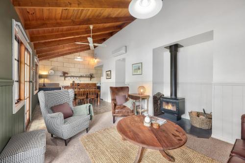 a living room with a table and a wood stove at Jamieson Cottages - Cottage ONE - Sleeps 4 in Howqua