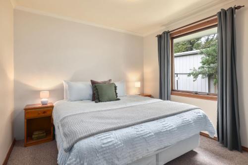 a bedroom with a large bed and a window at Jamieson Cottages - Cottage ONE - Sleeps 4 in Howqua