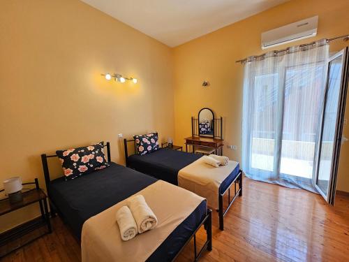 イプソスにあるStamatis Family Apartmentのベッドが2つと大きな窓がある部屋