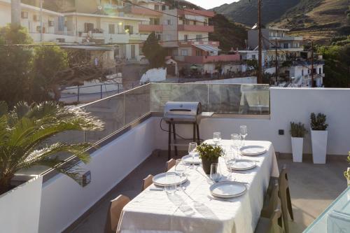 a table on the balcony of a building at Villa Iris, beachfront, with jacuzzi, up to 9 guests, Mpali beach, Rethymno! in Balíon