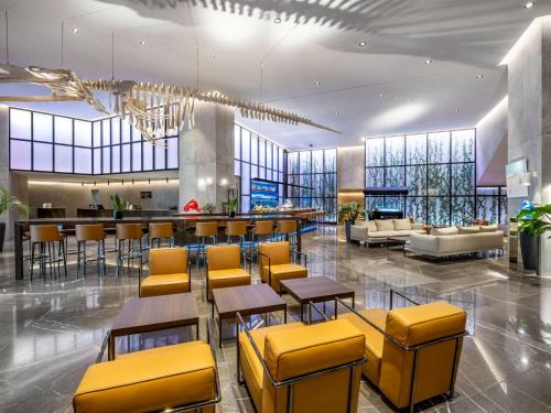 a lobby with tables and chairs and a bar at Pullman Tbilisi Axis Towers in Tbilisi City