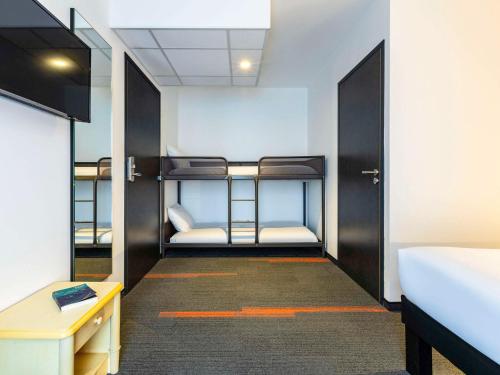 Ce dortoir dispose de lits superposés et d'un couloir. dans l'établissement greet Hotel Nancy Sud, à Houdemont