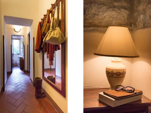 a lamp on a table with a book and a mirror at Country House il Ciliegio in Roccatederighi