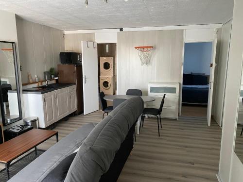 un salon avec un canapé et une table et une cuisine dans l'établissement Appartement 4 personnes Nanterre (La Defense-Mont Valérien), à Nanterre