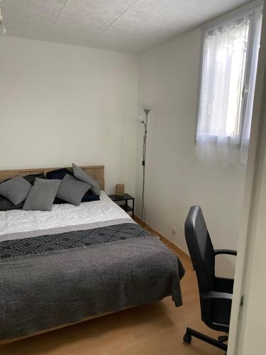 - une chambre avec un lit et une chaise noire dans l'établissement Appartement 4 personnes Nanterre (La Defense-Mont Valérien), à Nanterre