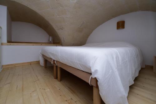 um quarto com uma cama grande e lençóis brancos em Casa Vacanze Ranieri em Grottaglie
