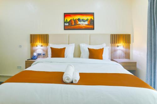 a bedroom with a bed with a white animal on it at Hamasvile Hotel Utako Abuja in Abuja