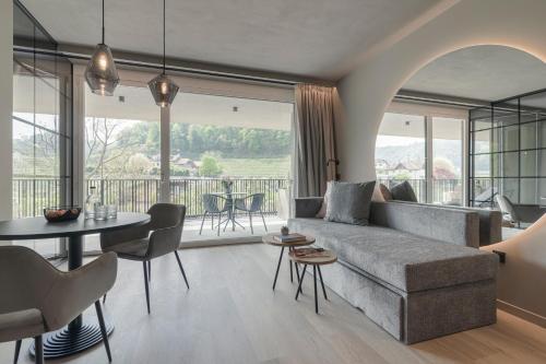 a living room with a couch and a table at Belia Lofts - ADULTS ONLY - Apartments in Appiano sulla Strada del Vino