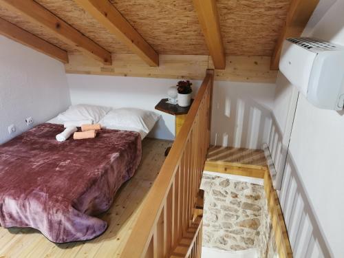 um quarto com uma cama num pequeno quarto em Runjini dvori em Kukljica