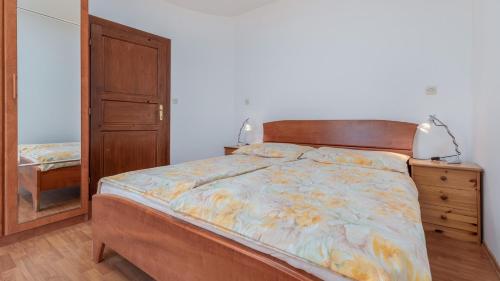 een slaapkamer met een bed, een dressoir en een spiegel bij Apartmány Medulin in Medulin