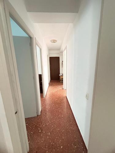 un pasillo vacío de un apartamento con paredes blancas y suelos rojos en piso en zapillo, en Almería