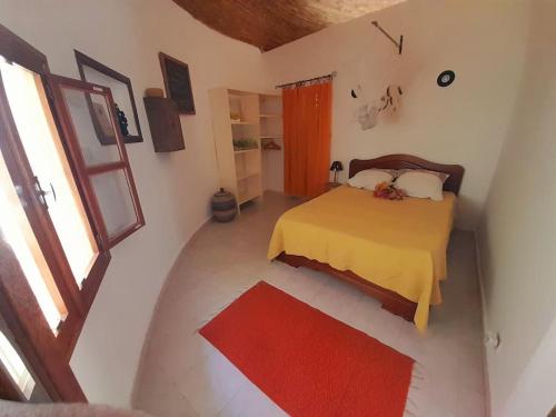 萨利尼亚拉尔Cosy Case avec son Jaccuzi privé Saly的一间卧室配有一张床和红色地毯