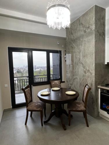 een eetkamer met een tafel en stoelen en een raam bij Platinum in Bisjkek