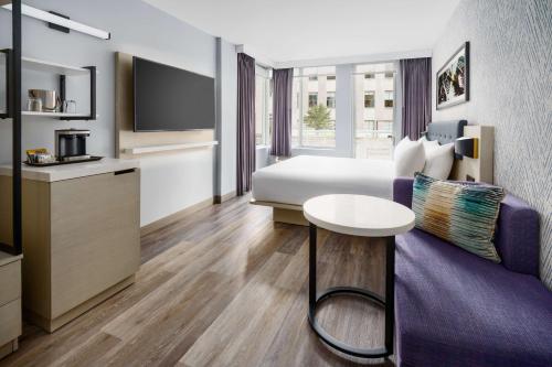 a hotel room with a purple couch and a table at DoubleTree by Hilton New York Midtown Fifth Ave in New York