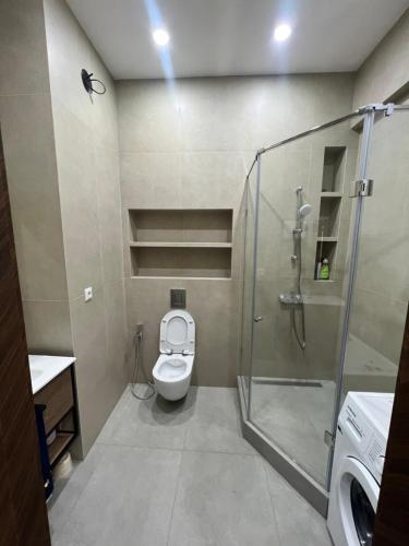een badkamer met een douche, een toilet en een wastafel bij Platinum in Bisjkek