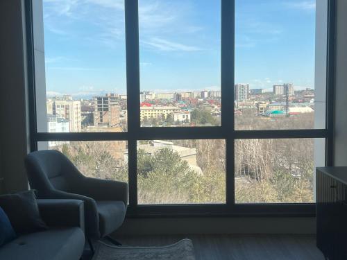 een woonkamer met uitzicht op de stad vanuit een raam bij Platinum in Bisjkek