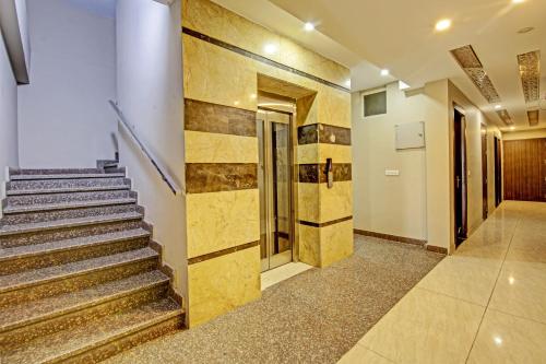 a lobby with a staircase with gold tile walls at Townhouse 1239 Grand Inn in Ghaziabad