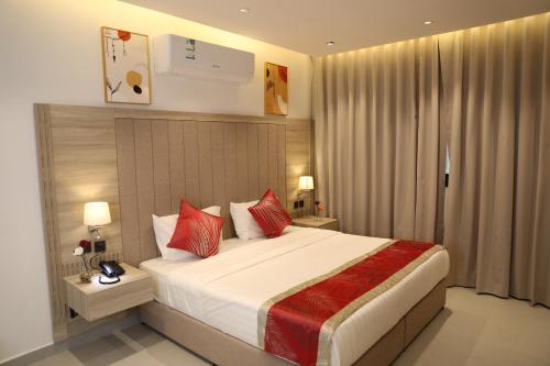 ein Schlafzimmer mit einem großen Bett mit roten Kissen in der Unterkunft فندق فيرانو in Riad