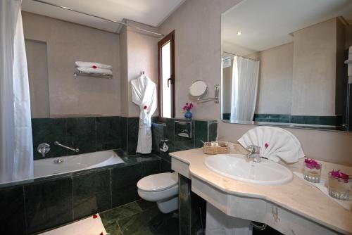 a bathroom with a sink and a toilet and a tub at Zalagh Kasbah Hotel & Spa in Marrakech