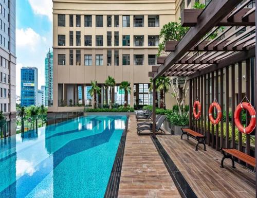 a swimming pool with benches and a building at Saigonroyal Residence - Smile Home -luxury Infinity pool in Ho Chi Minh City