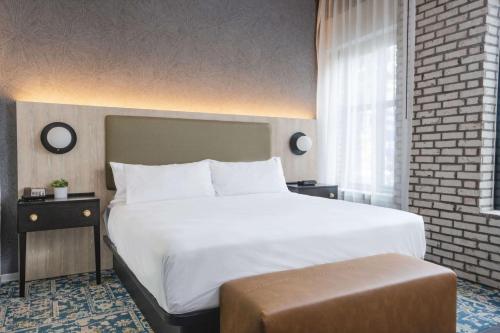 una camera da letto con un grande letto bianco e una finestra di Origin Atlanta, a Wyndham Hotel ad Atlanta