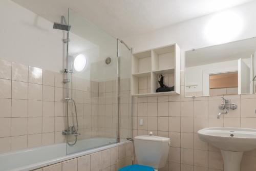 a bathroom with a toilet and a tub and a sink at Sun Valley Apartments in Maishofen