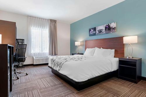 a hotel room with a bed and a television at Sleep Inn & Suites Fort Walton Beach - Destin West in Fort Walton Beach