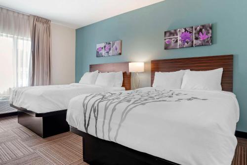a hotel room with two beds and a window at Sleep Inn & Suites Fort Walton Beach - Destin West in Fort Walton Beach