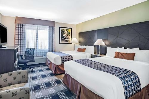 ein Hotelzimmer mit 2 Betten und einem Stuhl in der Unterkunft Express Inn in Champaign