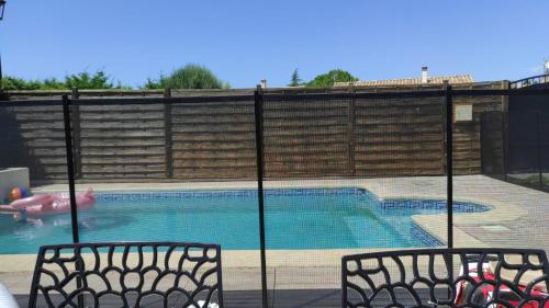 a swimming pool with two chairs and a person in the water at Maison cosy avec piscine au port - proche Narbonne in Bages