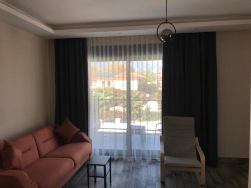 een woonkamer met een bank en een groot raam bij Tanem Suit in Antalya