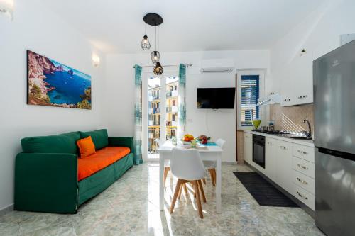 a living room with a green couch and a kitchen at Divina suite Cavaliere in Maiori