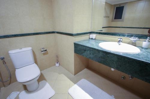 a bathroom with a toilet and a sink at Aman Plaza in Juffair