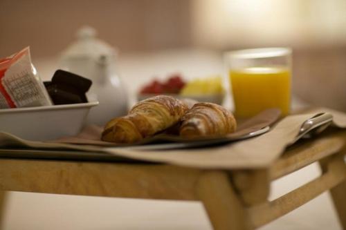 a table with a plate of croissants and a glass of orange juice at La Valle Del Sole Country House in SantʼIppolito