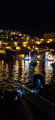 una ciudad iluminada por la noche con barcos en el agua en Un Angolo di Casa, en SantʼAgata