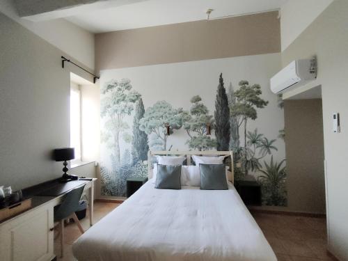 a bedroom with a bed with a painting on the wall at L'Art des Mets by Côté Jardin in Conilhac-Corbières