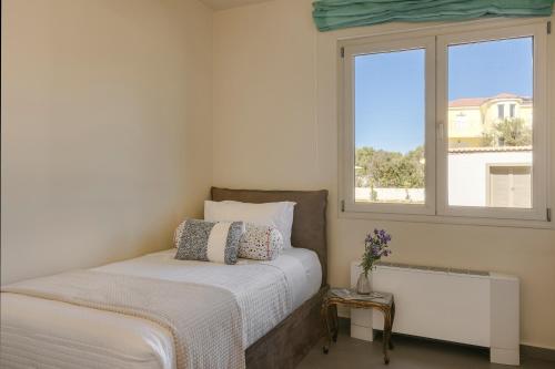 a bedroom with a bed and a window at Villa Felicity in Svoronata