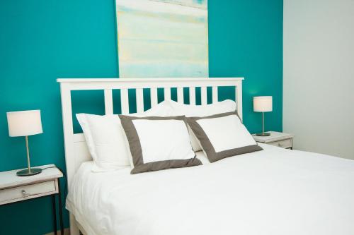 una camera da letto con un letto bianco e pareti blu di Villa Lucy - By AZ Rentals a Puerto del Carmen