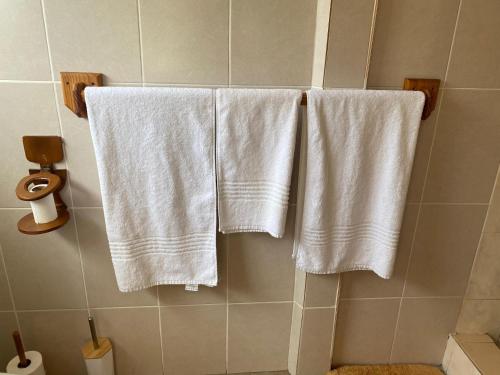 três toalhas brancas penduradas numa parede numa casa de banho em Pristine 1 Bed Cottage in Northern suburbs - 2222 em Kingsmead