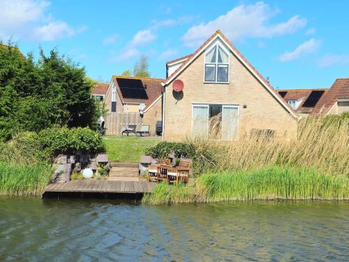 a house with a dock next to a body of water at Kustverhuur, Park Scheldeveste Zwin 065 in Breskens