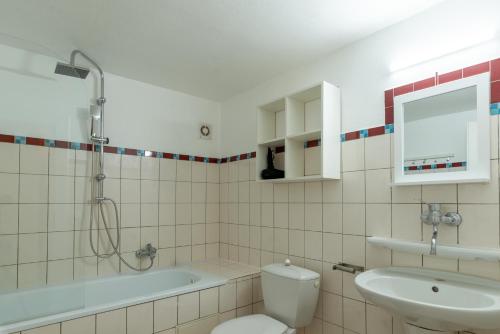 a bathroom with a sink and a toilet and a bath tub at Sun Valley Apartments in Maishofen