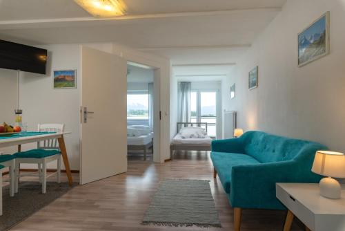 a living room with a blue couch and a table at Sun Valley Apartments in Maishofen