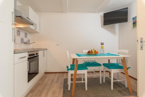 a small kitchen with a table with chairs and a table at Sun Valley Apartments in Maishofen